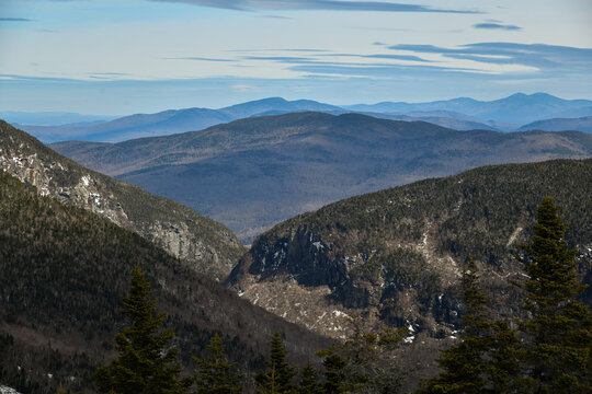 View From Mt. Mansfield Vermont At Stowe Ski Resort To Notch Path To Smugglers Notch. Late Spring Time With Snow On The Mountains And Blue Sky With Clouds.