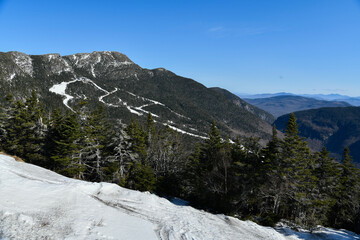 Fototapeta na wymiar View from Mt. Mansfield Vermont at Stowe ski resort. Late spring time with snow on the mountains and blue sky.