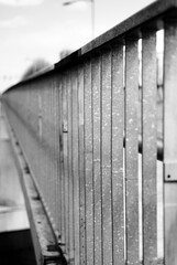 The symmetrical image of the steel railing on the bridge conveys the feeling of a rigid, solid support and draws attention to the geometric precision of the image.