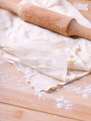 Filo dough and rolling pin on the wooden board 