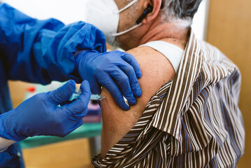 nurse hand with syringe giving covid19 or coronavirus vaccine in clinic. concept of covid...