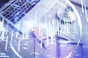 Business theme hologram drawings over computer on the desktop background. Top view. Multi exposure....