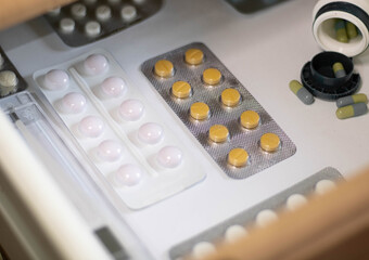 White medical pills in the wooden household drawer shelf at home from office table closeup. Tablet drugs virus. Cure at home by yourself , self-isolation recovery
Описание (на английском языке)162