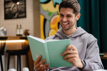 Smiling young man reading book