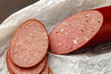 Chopped meat sausage on wooden board close up