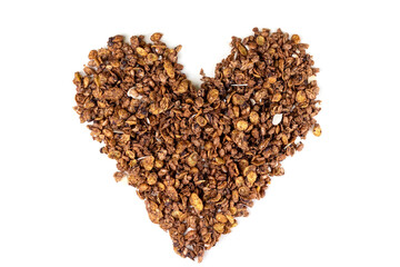 Heart shape from organic homemade roasted granola cereal with oats, flax, almonds, chocolate isolated on white background. Top view muesli