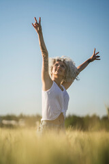 Chica con el pelo muy rizado posando en un campo de trigo