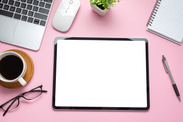 Mock up. Digital tablet blank white screen on the desk pink background.
