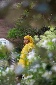 Black Muslim Woman in a yellow scarf in nature