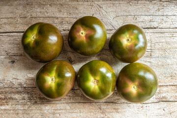 Group of organic green tomatoes, on a wooden board.