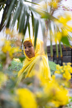 Black Muslim Woman in a yellow scarf in nature