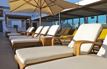 Luxury sun loungers and deck lounge chairs on outside terrace, patio or balcony sun deck of luxury...