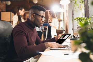 Colleagues working together in modern office using devices and gadgets during negotiations