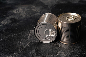 Obraz premium Closed food tin cans on dark background