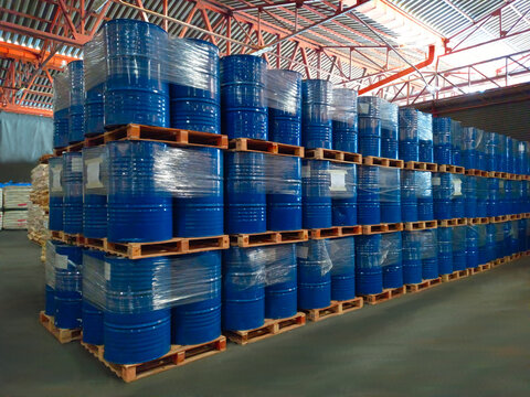 Many blue buckets are stacked on top of each other. In warehouse