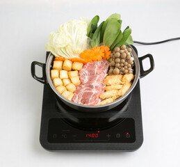 induction cooktop with sukiyaki pot isolated on white