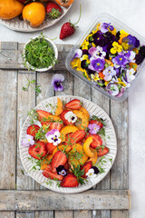 Fresh  salad with strawberries, Loquat fruit and edible flowers in a bowl. 