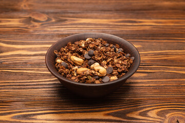 Chocolate granola cereal with nuts in a bowl.