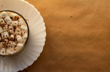 a cup of hot drink, with marshmallows, chocolate and cinnamon. 