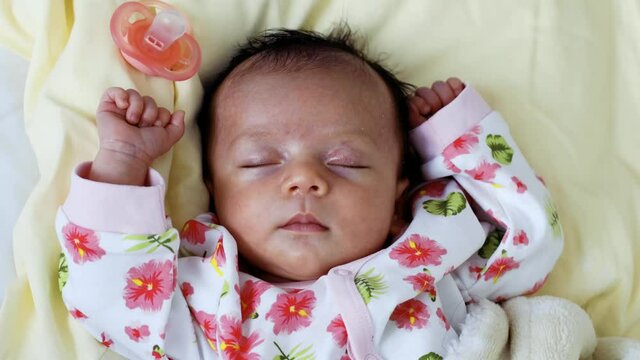 Vue en rotation d'un b&eacute;b&eacute; qui dort avec les bras en haut