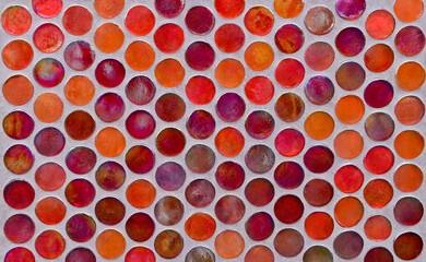Round pieces of glass mosaic on concrete wall. Abstract background.