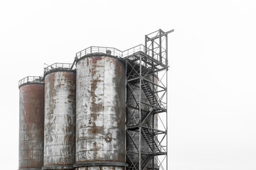 Old abandoned tanks for storing industrial products and fertilizers at a plant or factory
