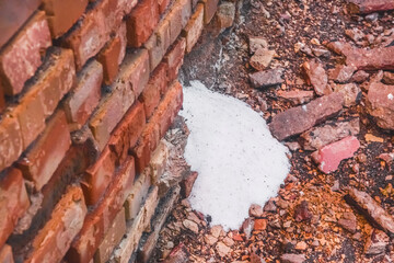 Fototapeta premium White ammonia saltpeter, fertilizer woke up through the destroyed old brick wall of the industrial warehouse with fertilizer