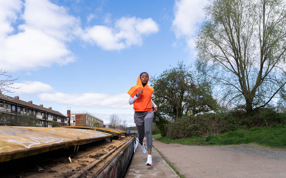 Black Muslim woman runner on the canal