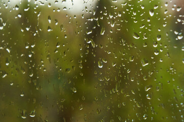 Rain drops falls on window glass in spring