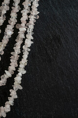 white necklace isolated on a black stone texture, macro