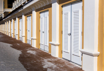 Infinite white doors on a row with sandy entrances.