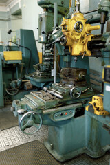 Drilling machine in the old shop. Drilling machine parts and spindle with drills.