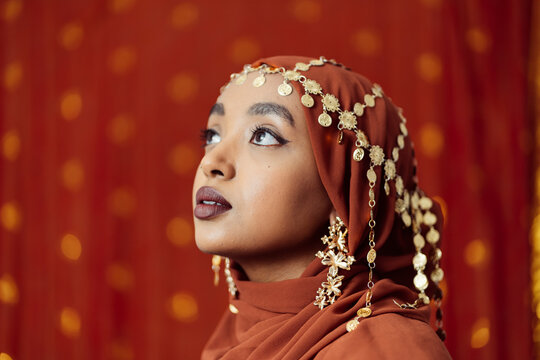 Black Muslim Woman with traditional jewellery headpiece over hijab