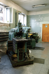 Front view of an old metal lathe in a lathe shop. The lathe components and the spindle.
