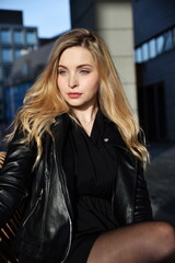 Young woman in Wroclaw city. Female student with blonde hairs, wearing black jacket.
