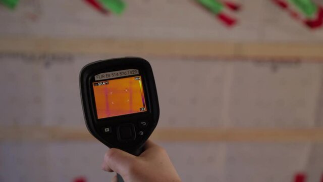 Close up shooting of a thermal imaging camera scanning the interiors of an eco friendly house in construction insulated with hemp wool.