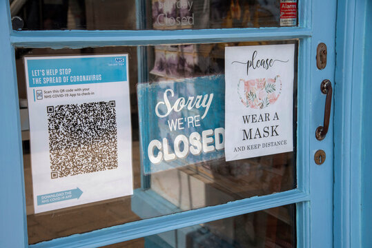 England, UK. 2021.  Shop Door With Closed Sign And Test And Trace Covid-19 QR Code For NHS App. Wear A Mask Sign.