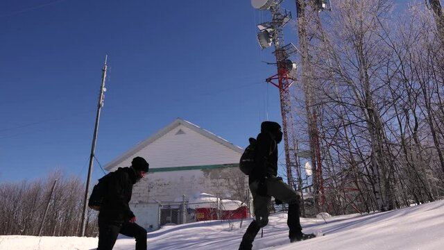 Videography of a beautiful snowy area, featuring two explorers making documentary of cellular communication towers causing electromagnetic pollution.