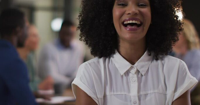 Portrait of african american businesswoman in a meeting room looking to camera laughing