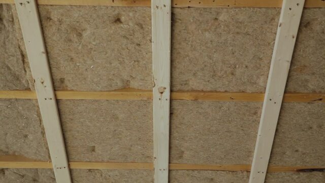 Camera slowly revealing details of the the ceiling and turning around on itself revealing interiors covered with sheets of insulating hemp wool. 