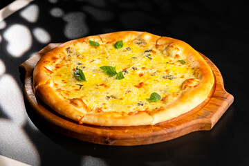 Pizza is not a wooden board. Black background. close-up.