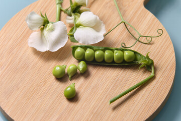 Legumes - The pod of peas with the white flower typical of the pea plant placed on the wooden tray