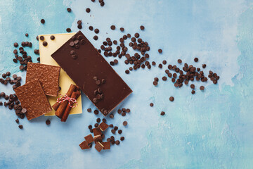 Various types of chocolate bars, cinnamon  and  dark chocolate chip. Assorted bars of dark, white and milk  chocolate,  partially broken. Top view, blank space