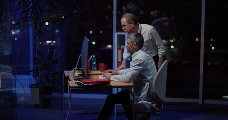 Multi-generation facility office working at night. Repairman soldering iron fixing materials while...