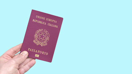 Italian digital passport of European Union held by hand isolated on a light blue background