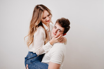 love, passionate and beautiful couple have fun and cuddle against the white wall