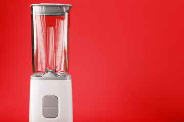 Blender with cup on red background with free space.