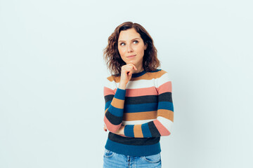 Curious young woman wearing casual jeans and striped sweater