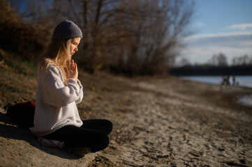 Practice of meditation and interaction with nature. Girl near river