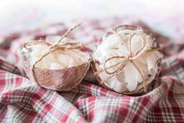 Fototapeta na wymiar Coconut dried candies stored in coconut shells decor with rope